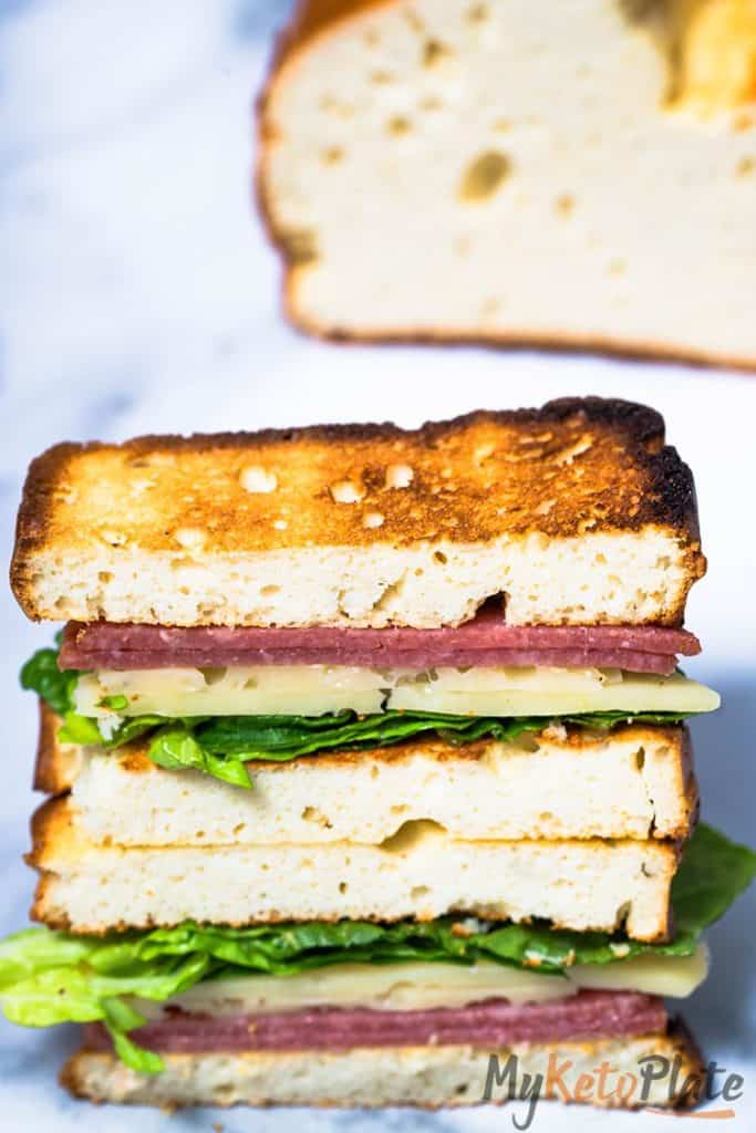 Overhead view of perfectly cut sandwich halves on a tray, showing the golden edges of egg-free bread and fresh filling.