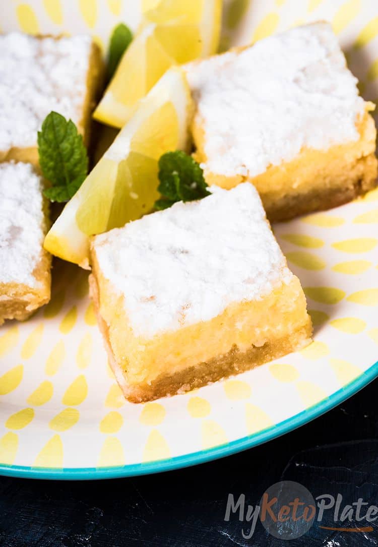 Keto Lemon bars on a plate with a sliced lemon and mint leaves