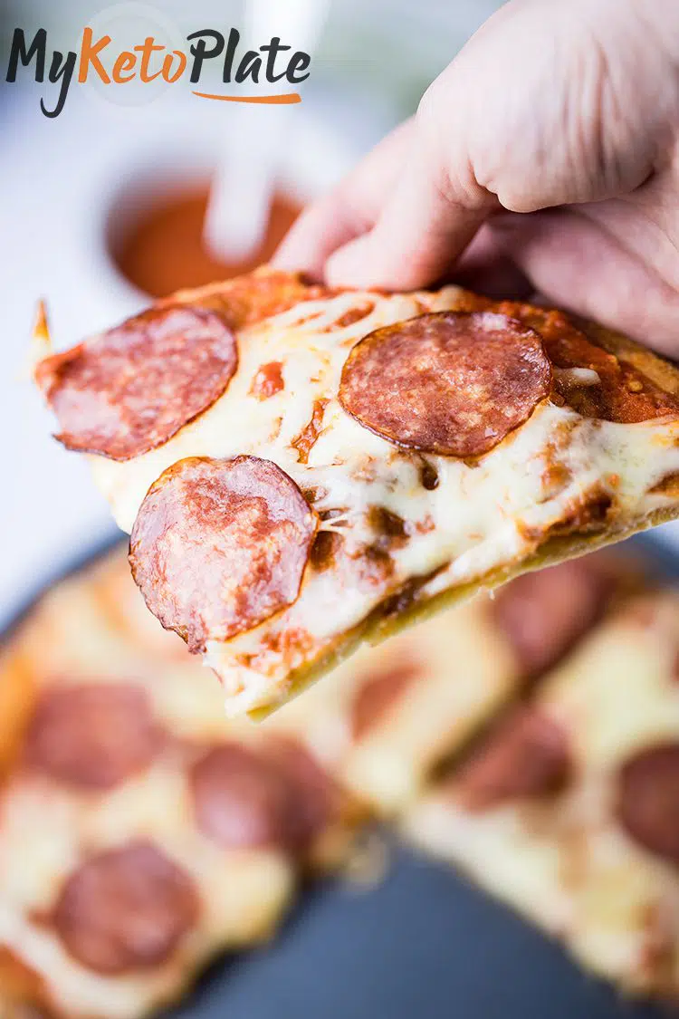 A freshly baked slice of keto pizza, highlighting the crispy edges and cheesy topping.