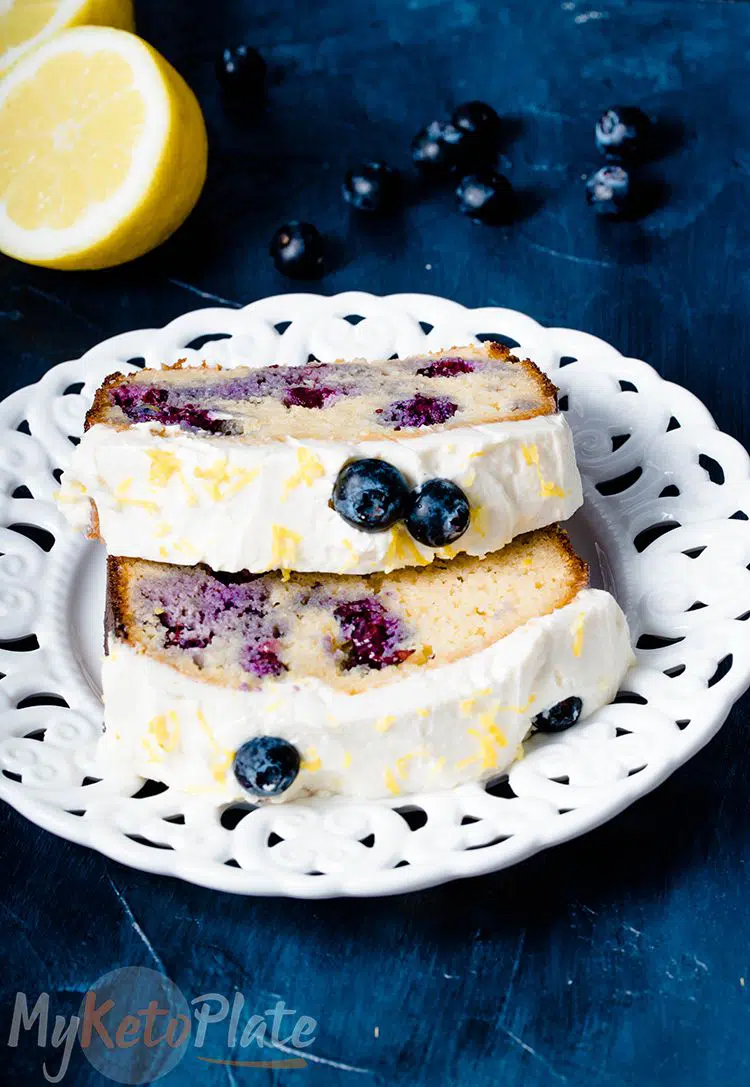 2 slices keto blueberry bread on a white plate and a black background