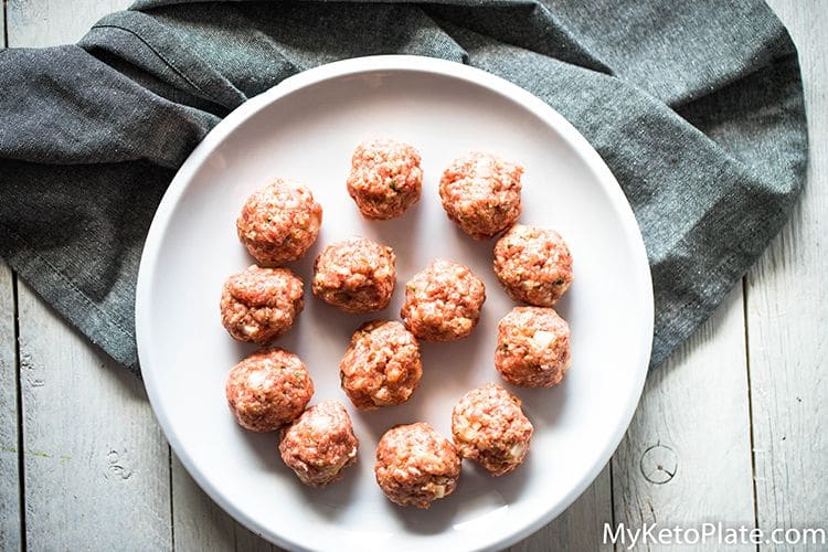 uncooked meatballs on a white plate