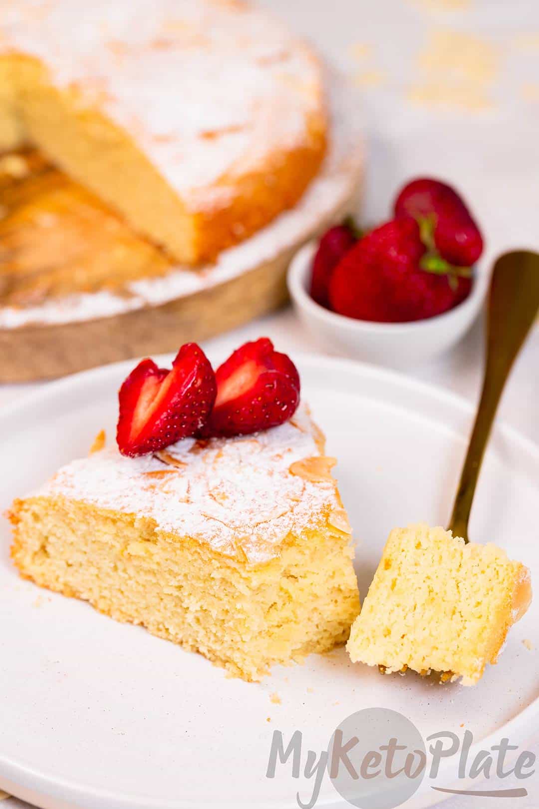 A bite of moist almond flour cake, showing its fluffy texture and golden crust.
