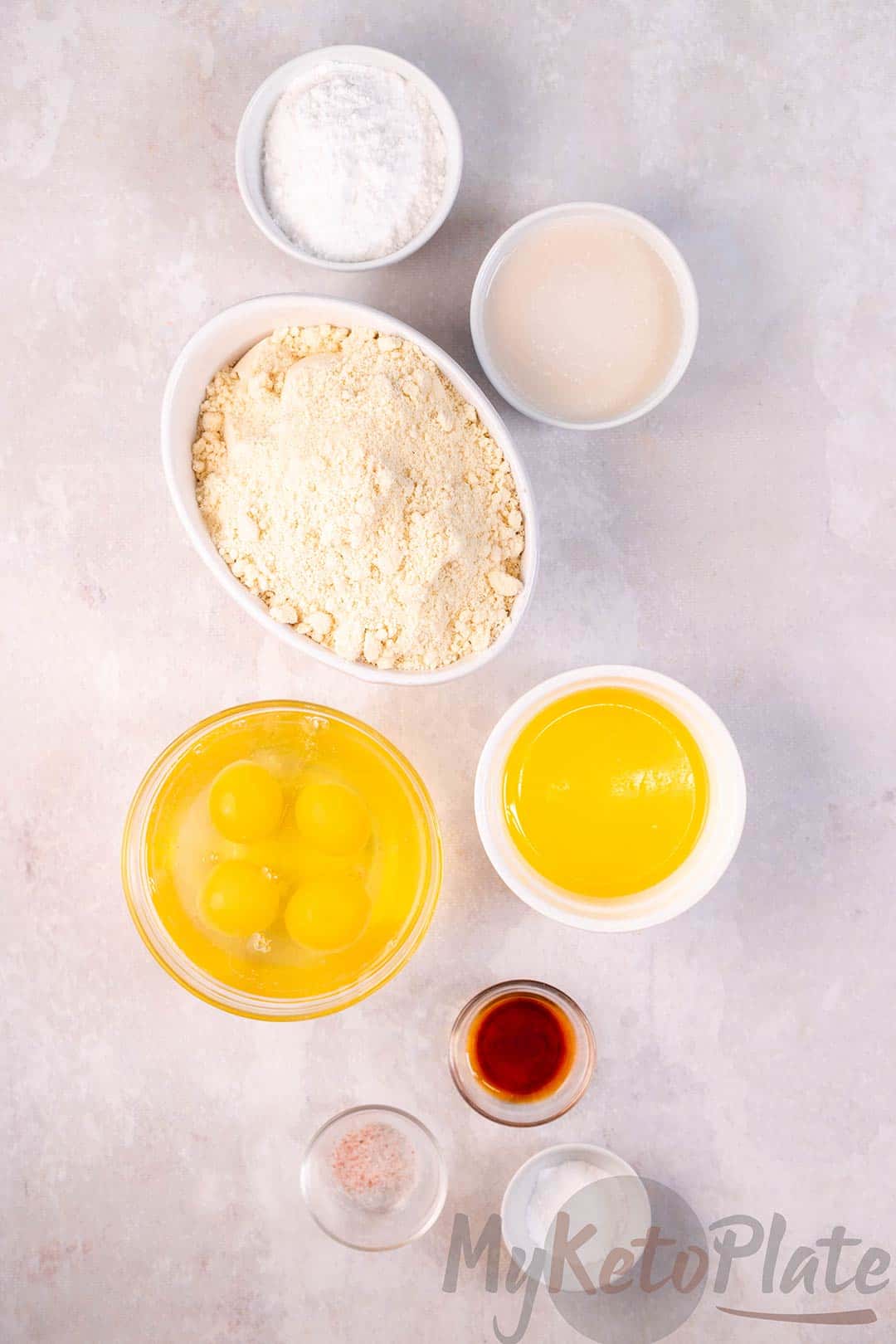 Essential ingredients for a gluten-free almond flour cake, including almond flour, sweetener, melted butter, and vanilla extract.
