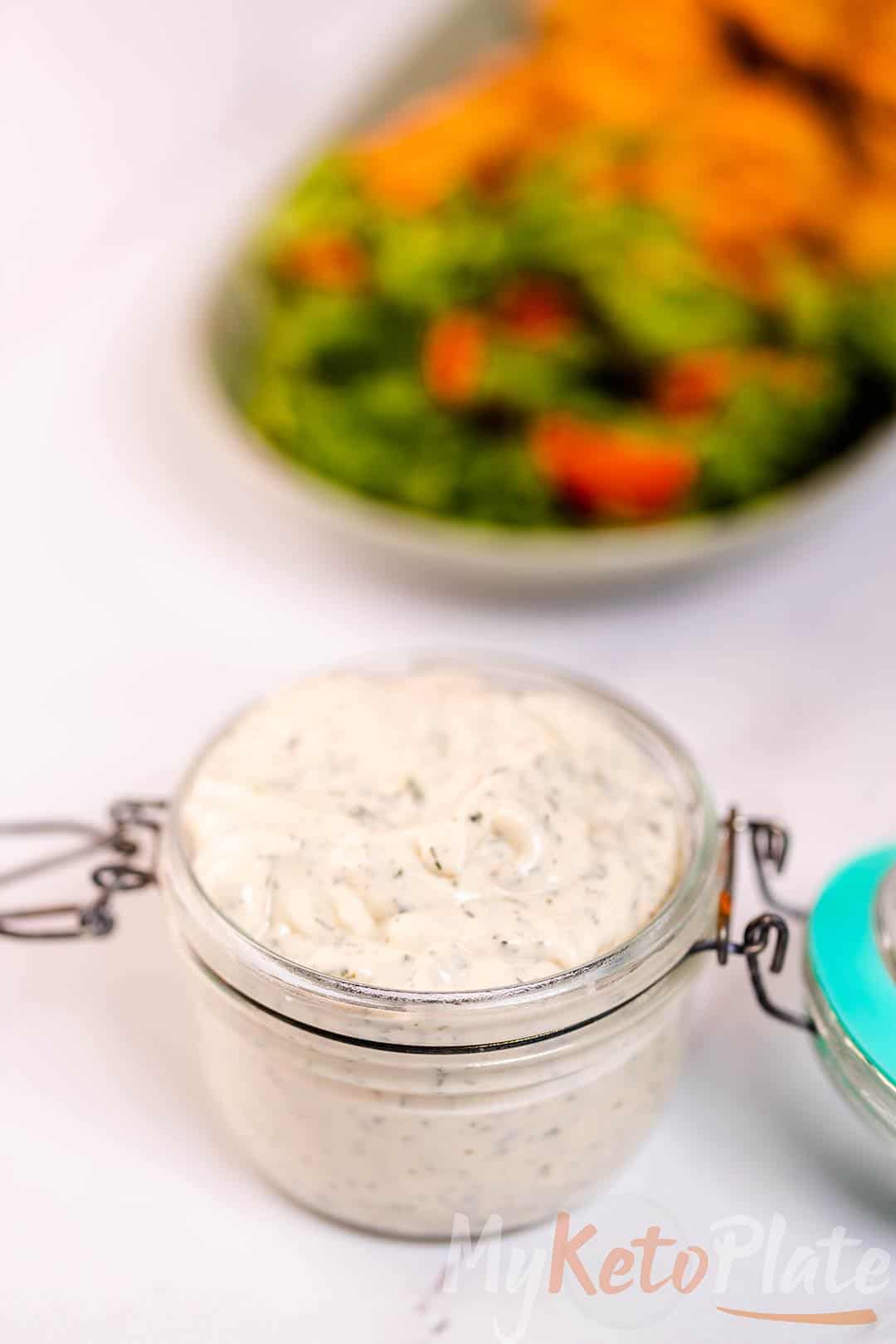 A glass jar filled with homemade keto ranch dressing, ready to serve with fresh salads or chicken.