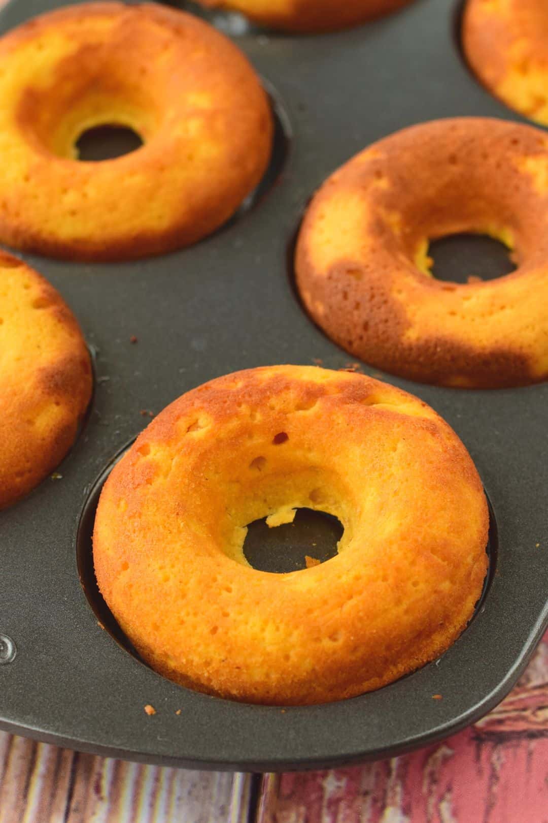 Golden, fluffy keto donuts with a perfectly round center, just out of the oven.
