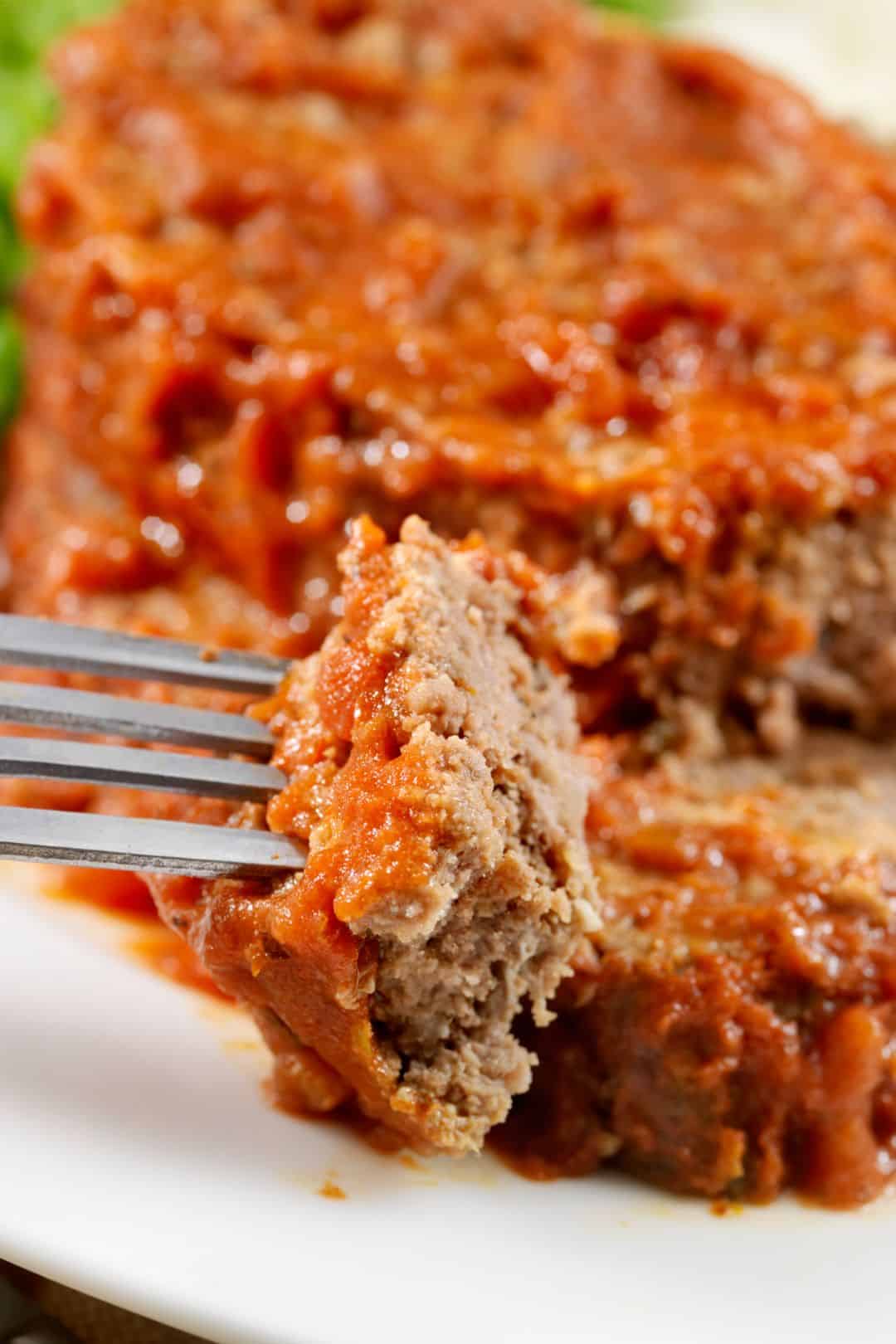 A tender and flavorful slice of keto meatloaf coated in a tangy, sugar-free glaze, ready to be enjoyed.