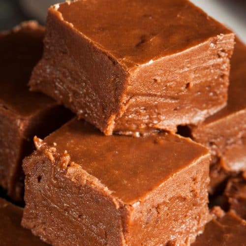 A batch of keto-friendly fudge squares arranged on a wooden board, showing their firm but creamy texture.