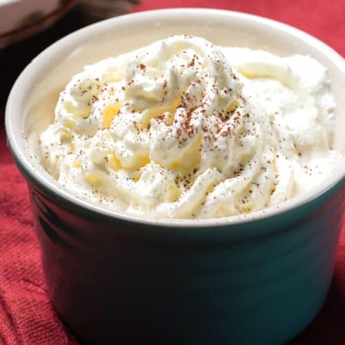 A creamy, sugar-free whipped topping in a bowl, dusted with cocoa powder for extra flavor.