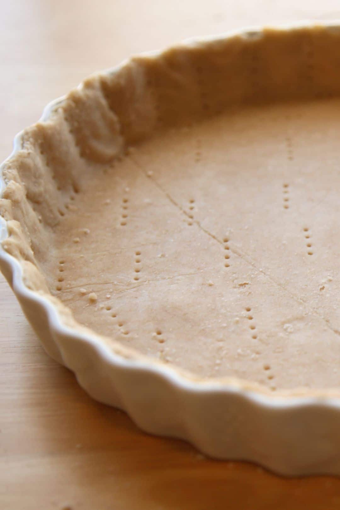 Raw pie crust pressed into a tart pan with a smooth finish.
