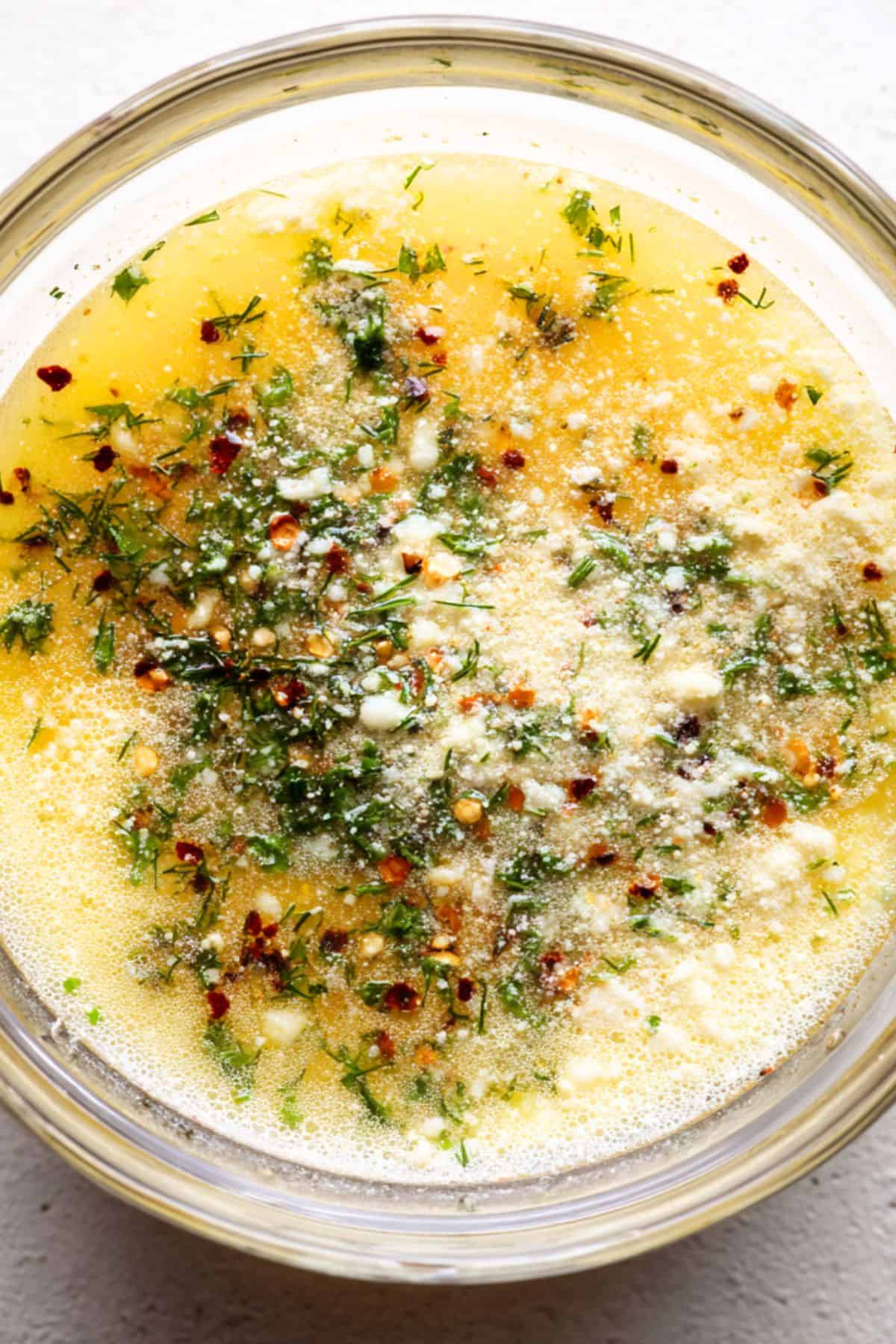 Close-up of creamy garlic butter sauce with parmesan and fresh dill for chicken skewers.