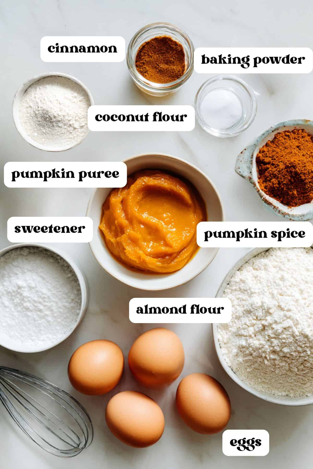 Flat lay of ingredients for keto pumpkin roll including eggs, almond flour, pumpkin puree, spices