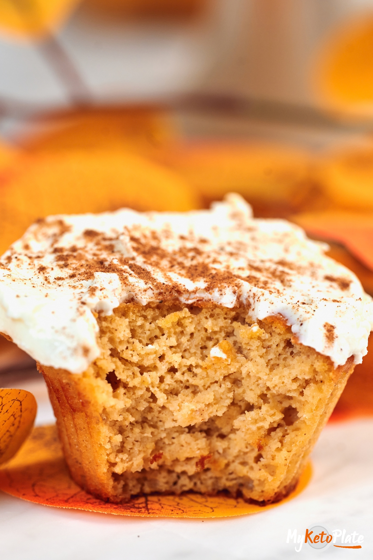 High-Protein Cottage Cheese Pumpkin Muffins 5 Close-up of a High-Protein Cottage Cheese Pumpkin Muffin with a bite taken out, showing the soft, moist pumpkin center and cinnamon cream cheese frosting.