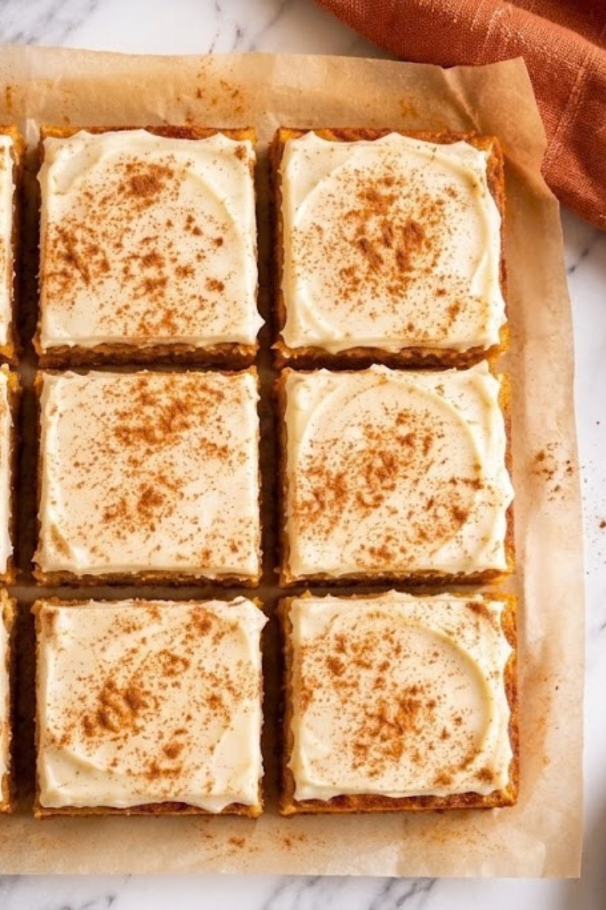 High-Protein Cottage Cheese Pumpkin Bars 6 High-Protein Cottage Cheese Pumpkin Bars cut into squares and topped with cream cheese frosting and cinnamon.